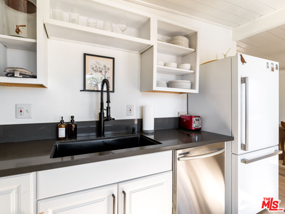 2724 Stonehill Avenue Joshua Tree, CA 92252 - Photo 15 of 65 a kitchen with granite countertop a refrigerator and a sink