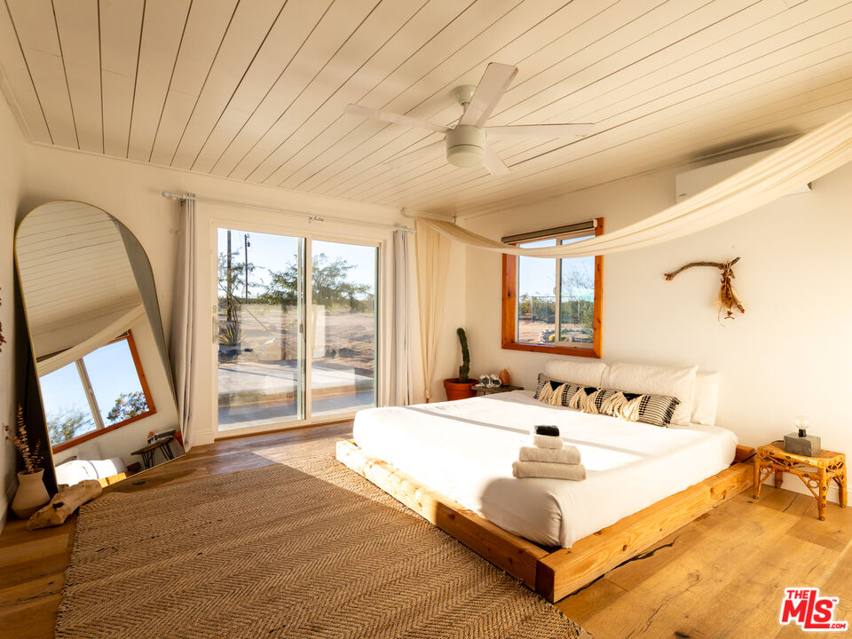 2724 Stonehill Avenue Joshua Tree, CA 92252 - Photo 21 of 65 a spacious bedroom with a bed and a large window