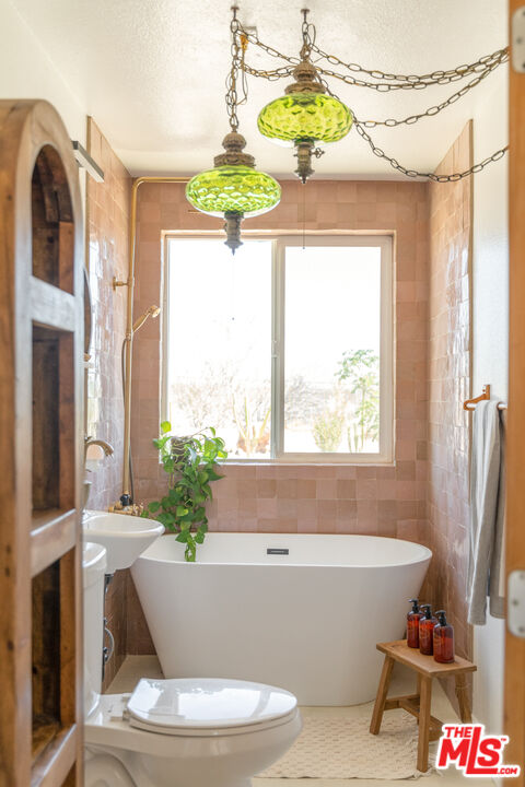 2724 Stonehill Avenue Joshua Tree, CA 92252 - Photo 26 of 65 a bath tub sitting next to a window