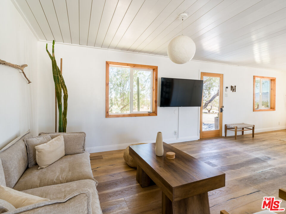 2724 Stonehill Avenue Joshua Tree, CA 92252 - Photo 9 of 65 a living room with furniture and a flat screen tv