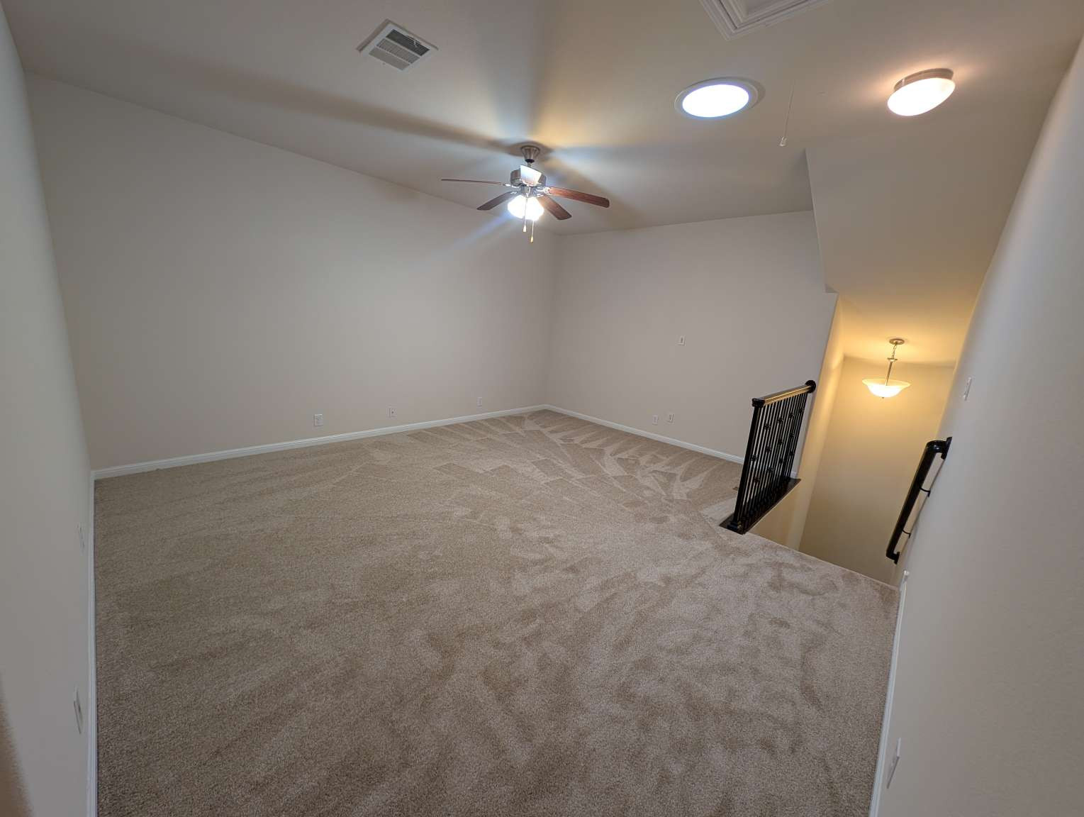 7301 Bandera Ranch Trail, Unit A Austin, TX 78750 - Photo 13 of 20 A spacious carpeted loft offers comfortable living with a ceiling fan and convenient staircase access.
