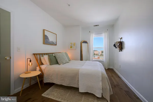 a bedroom with a bed and a painting on the wall