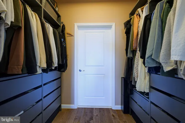 a view of walk in closet with clothes and shoes