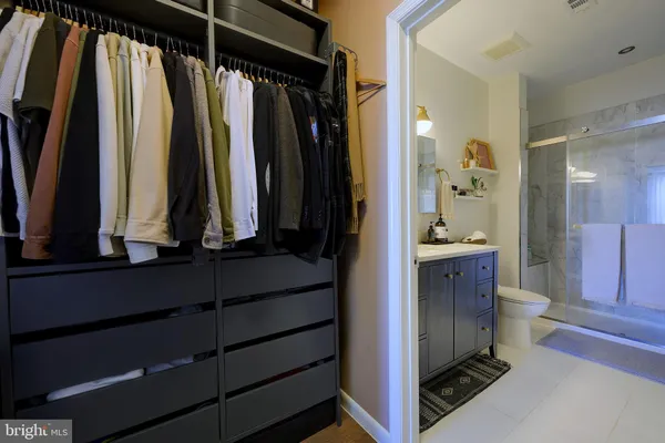 a view of walk in closet with clothes and shoes