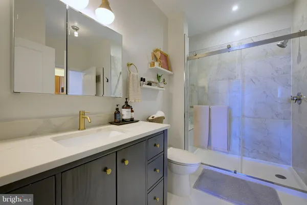 a bathroom with a sink a toilet and shower