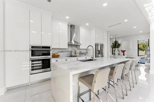 a view of a swimming pool with lawn chairs and large trees