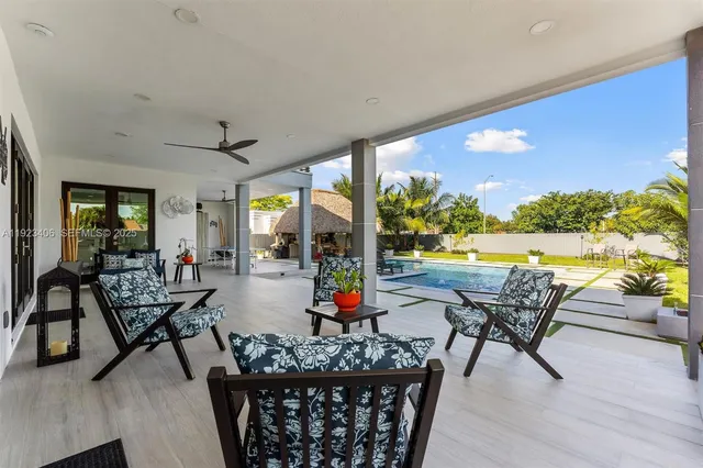 a view of swimming pool with outdoor seating and deck in the back