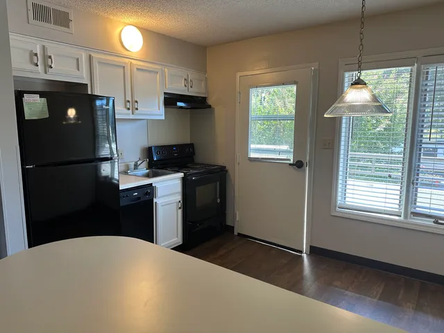 a kitchen with a refrigerator and a window