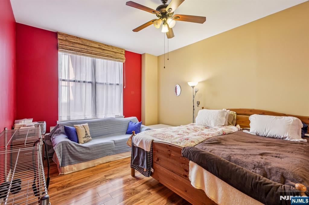 111 Mulberry Street, Unit 2V Newark, NJ 07102 - Photo 14 of 27 a bedroom with a bed and wooden floor