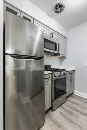 a kitchen with stainless steel appliances granite countertop a refrigerator and a stove