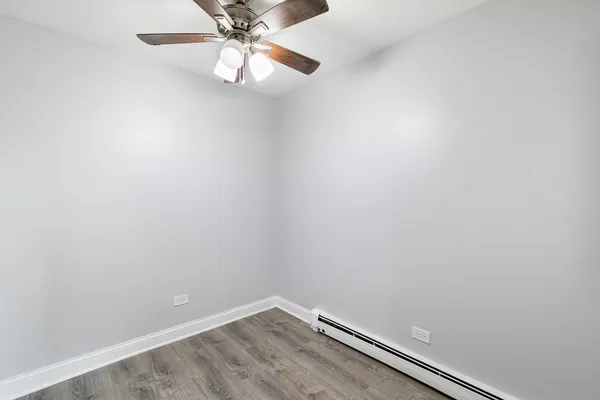 an empty room with a chandelier fan
