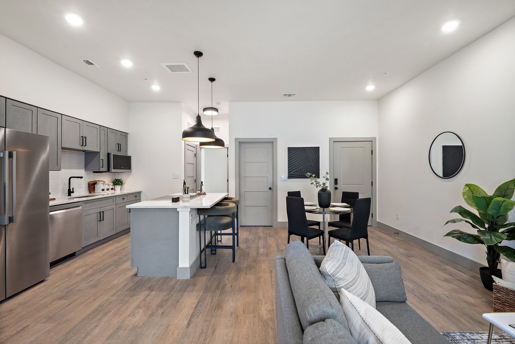 2450 Wickersham Lane, Unit 2012 Austin, TX 78741 - Photo 23 of 36 Kitchen featuring stainless steel appliances, a breakfast bar, gray cabinets, pendant lighting, and an island with sink