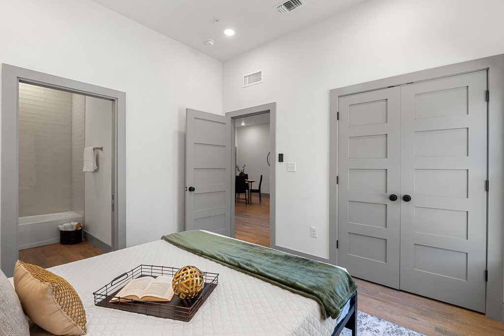 2450 Wickersham Lane, Unit 2012 Austin, TX 78741 - Photo 7 of 36 Bedroom with wood finished floors, ensuite bathroom, and a closet