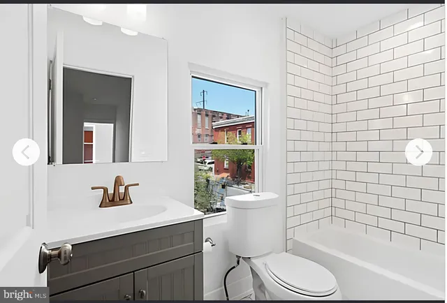 a bathroom with a toilet a sink a mirror and shower