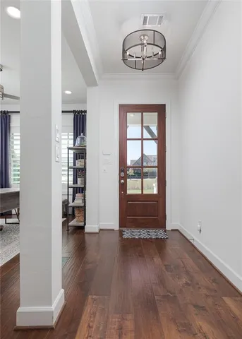 an empty room with wooden floor cabinet and windows