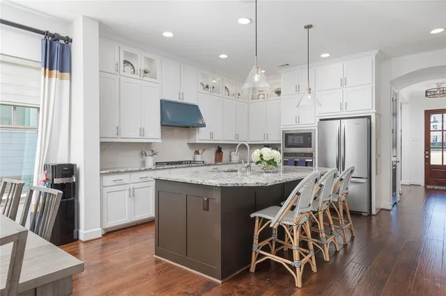 a kitchen with a table chairs refrigerator and microwave
