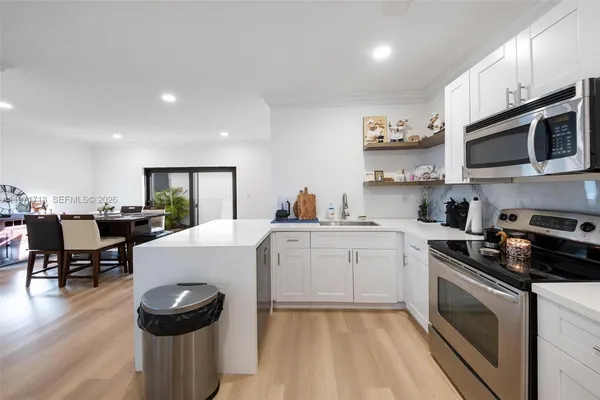 a kitchen with a sink a stove and cabinets