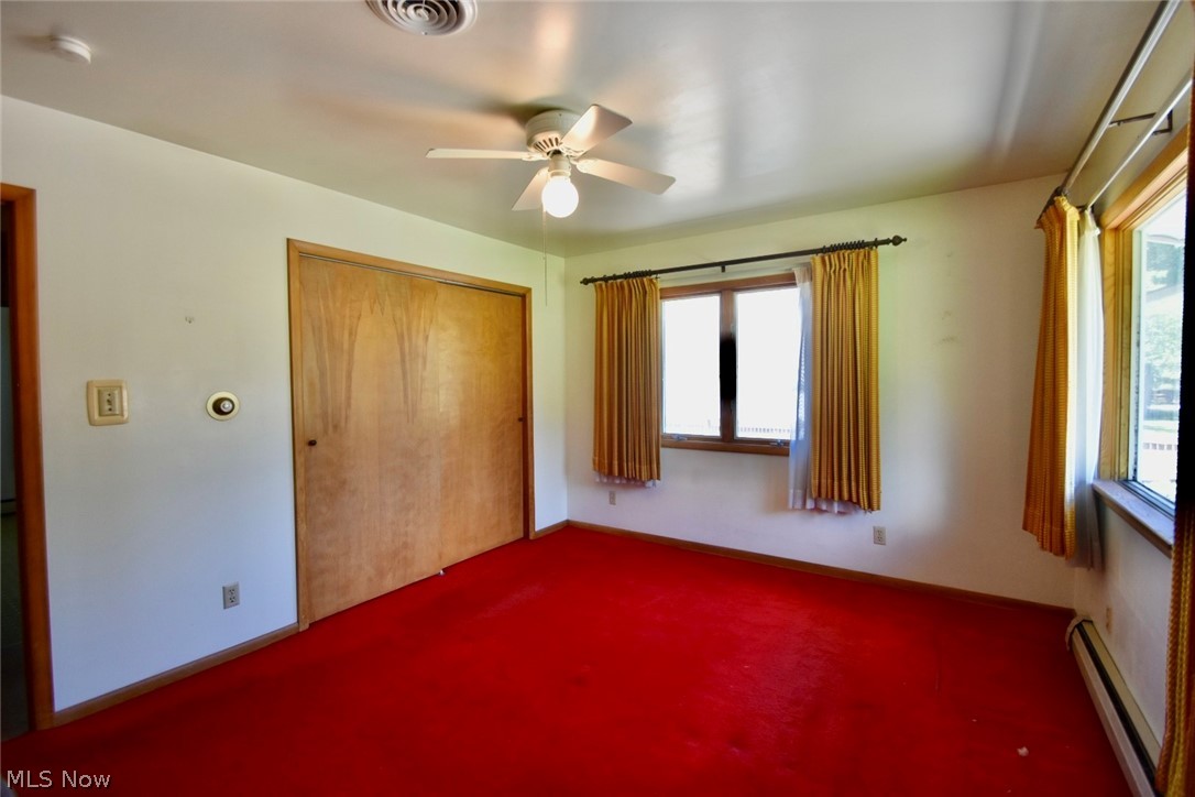 12840 South Reed Road Grafton, OH 44044 - Photo 13 of 27 Unfurnished bedroom with a baseboard heating unit, carpet floors, and multiple windows