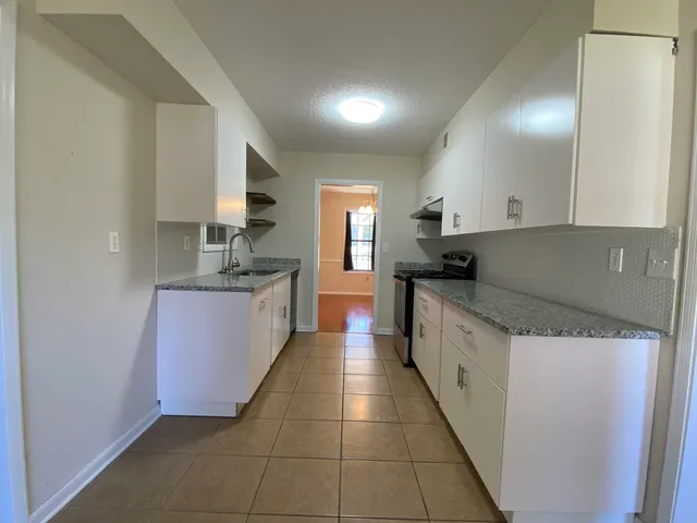 a large kitchen with a stove top oven and cabinets