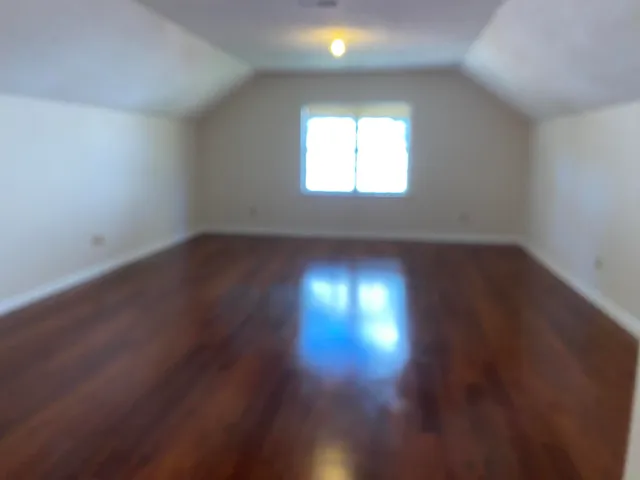 a view of room with wooden floor and windows