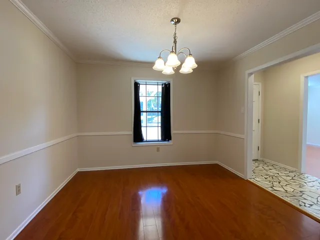 a view of a room with wooden floor and chandelier