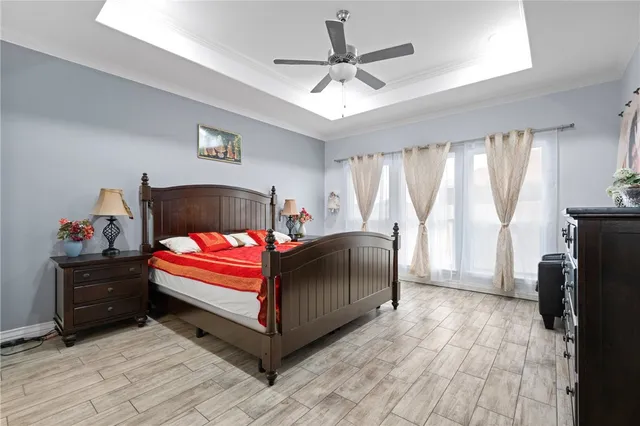 a bedroom with a bed next to a window with a flat screen tv