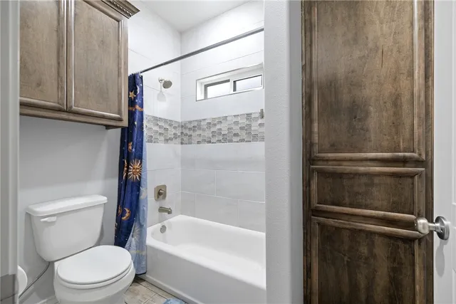 a white toilet sitting next to a bathtub