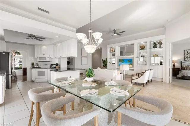 a view of a dining room and livingroom with furniture wooden floor and a chandelier