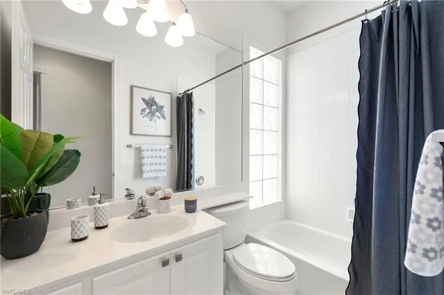 a bathroom with a granite countertop sink a toilet a mirror and shower