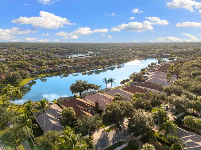 an aerial view of ocean and residential houses with outdoor space