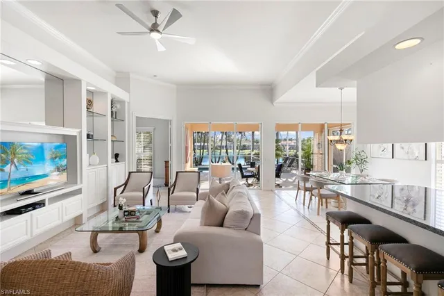 a living room with furniture a flat screen tv and a large window