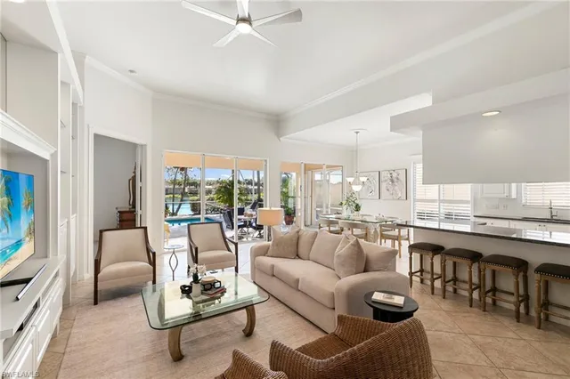 a living room with furniture kitchen view and large windows