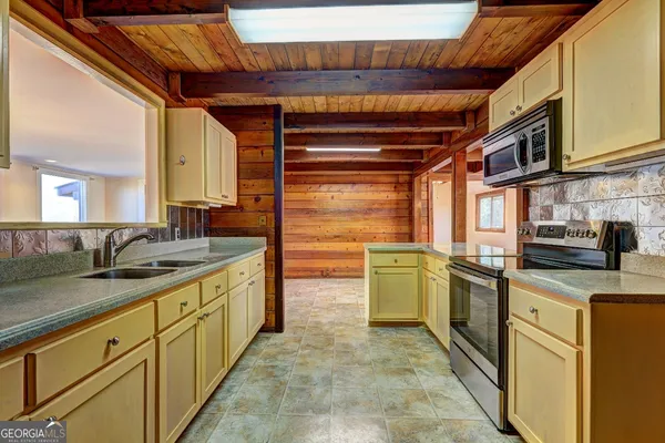 wooden floor in an empty room with a fireplace and a window