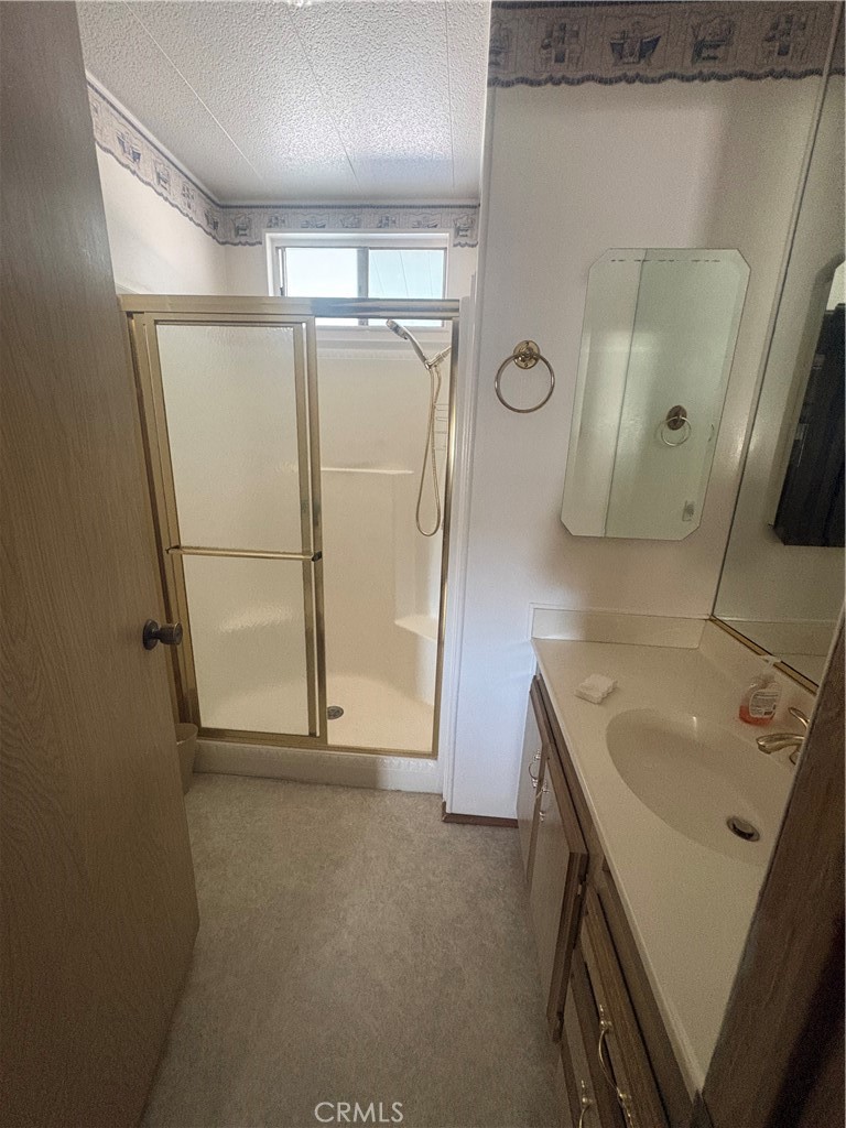 13393 Mariposa Road, Unit 114 Victorville, CA 92395 - Photo 15 of 18 a bathroom with a sink a mirror a vanity and shower