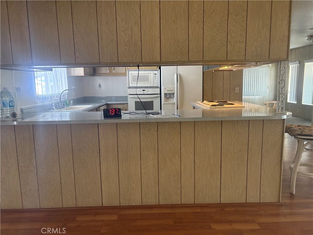 13393 Mariposa Road, Unit 114 Victorville, CA 92395 - Photo 3 of 18 a kitchen with stainless steel appliances wooden cabinets a table and chairs