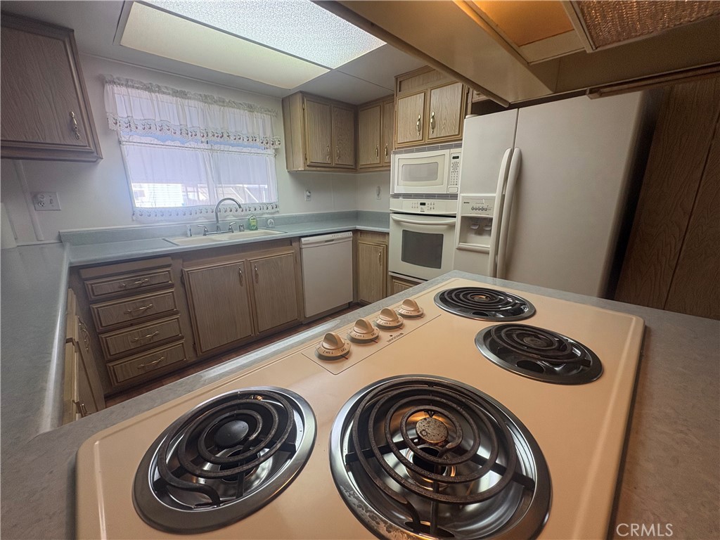 13393 Mariposa Road, Unit 114 Victorville, CA 92395 - Photo 4 of 18 a kitchen with a refrigerator and washer