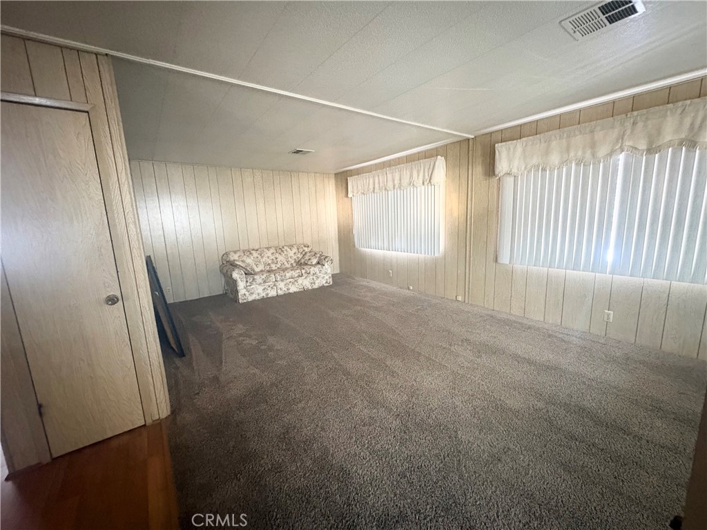 13393 Mariposa Road, Unit 114 Victorville, CA 92395 - Photo 9 of 18 a view of an empty room with wooden floor and a window