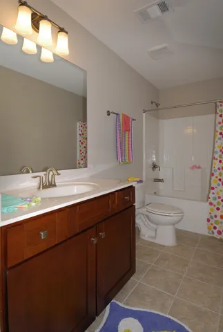 a spacious bathroom with a double vanity sink toilet and a mirror