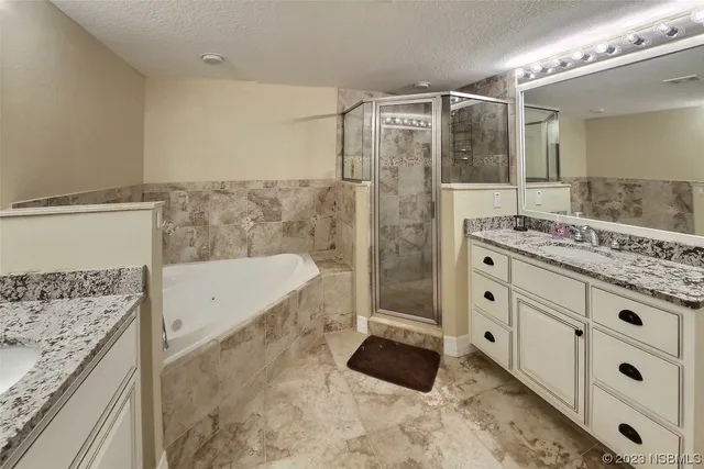 a bathroom with a granite countertop sink a mirror and shower