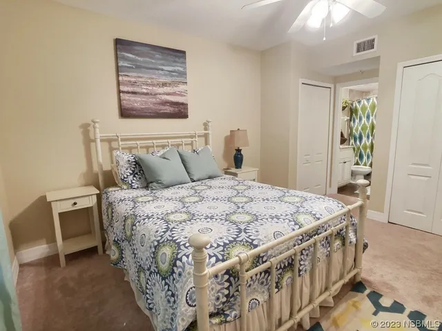 a bedroom with a bed a painting on the wall and a baby crib