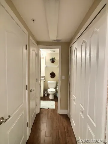 a bathroom with a glass door shower a toilet and a hardwood floor