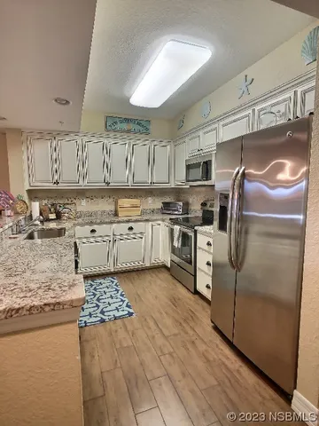 a kitchen with stainless steel appliances granite countertop a stove a sink and a refrigerator