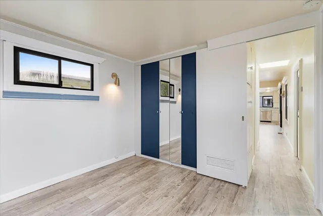 a view of empty room with wooden floor and window