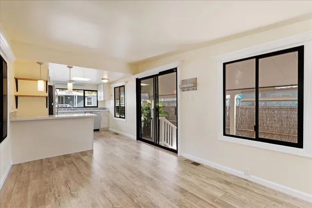 a view of a big room with wooden floor and windows