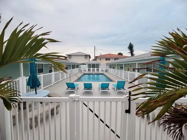 a view of a house with a small yard and wooden deck
