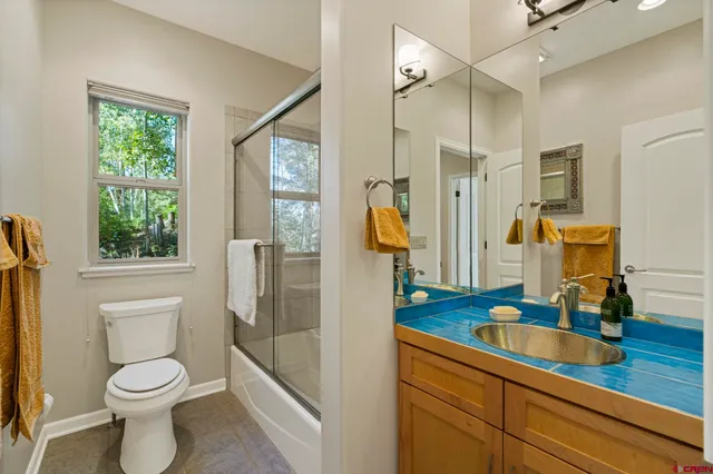a bedroom with a bed potted plant on the dresser and a potted plant