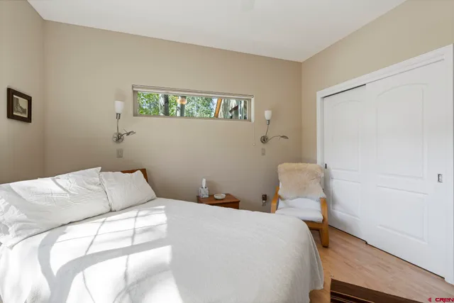 a kitchen with granite countertop a stove a sink a dining table and chairs with wooden floor