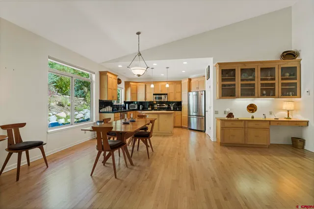 a kitchen with stainless steel appliances granite countertop a refrigerator a sink a stove and a refrigerator