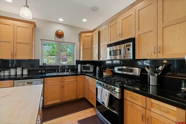 a kitchen that has a refrigerator a stove and a refrigerator with wooden floor