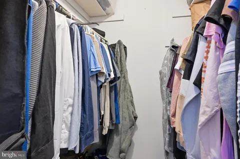 a view of walk in closet with clothes and shoes